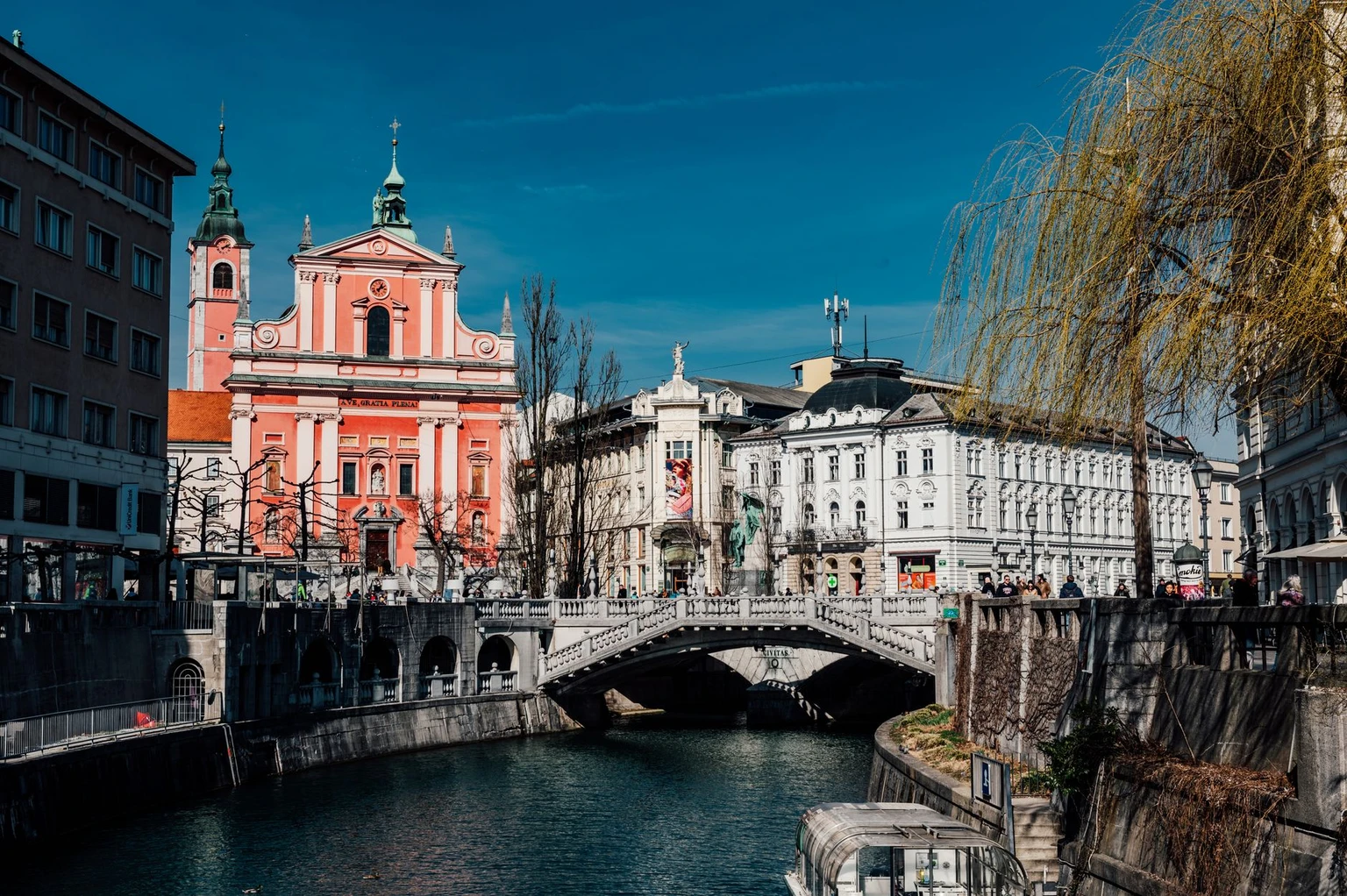 Explore Ljubljana's iconic Triple Bridge and vibrant Franciscan Church, nestled in the charming old town by the river.