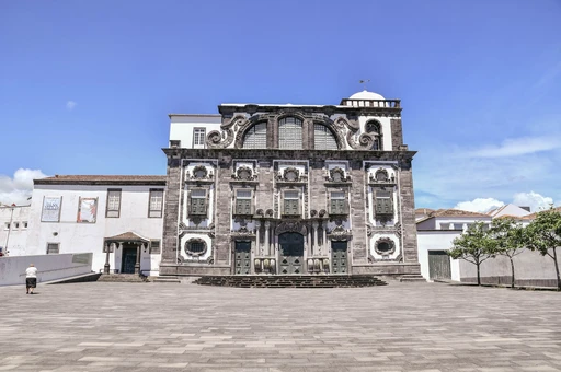 A beautiful Baroque-style church in São Miguel, Azores, under a clear blue sky.