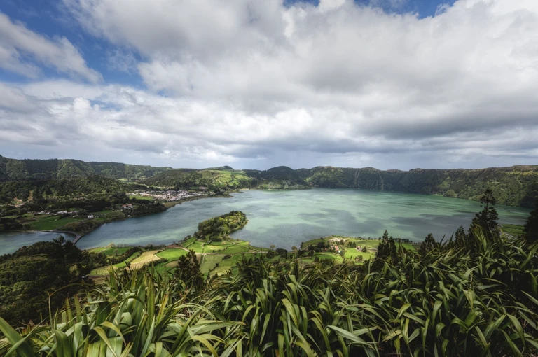 Walk the rim of a crater with a village at the bottom