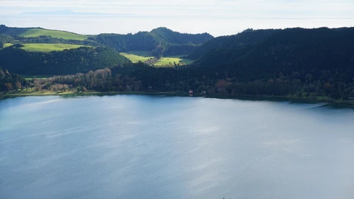 A breathtaking aerial view of Lagoa das Furnas surrounded by lush greenery in the Azores, Portugal.