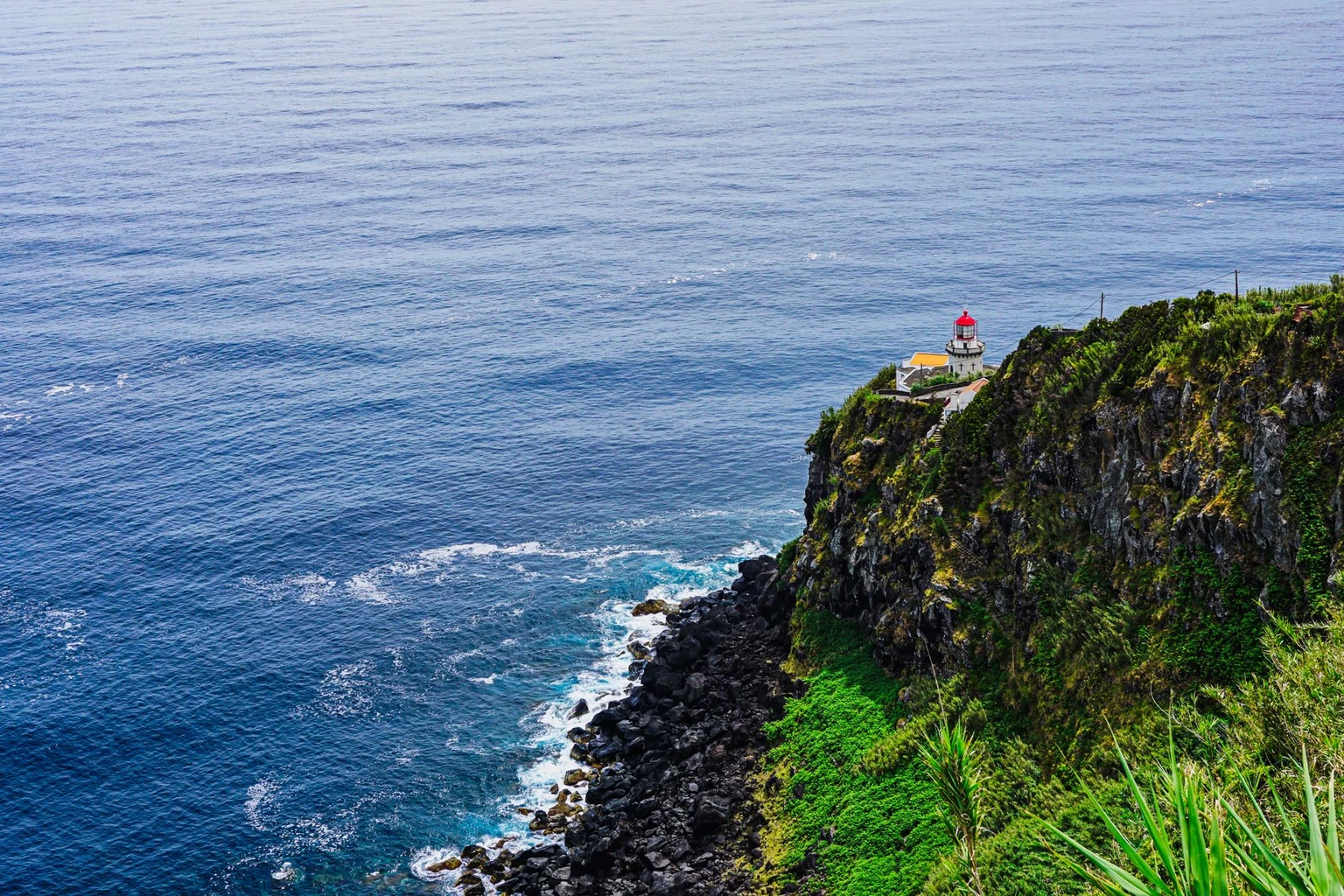 Scenic view of Arnel Lighthouse perched on a cliff in the Azores.