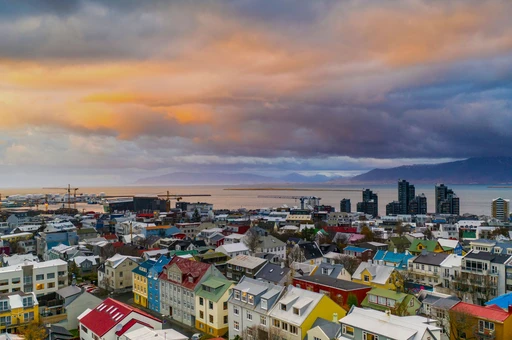 Aerial view of Reykjavik, Iceland, showcasing colorful houses and a stunning sunset.