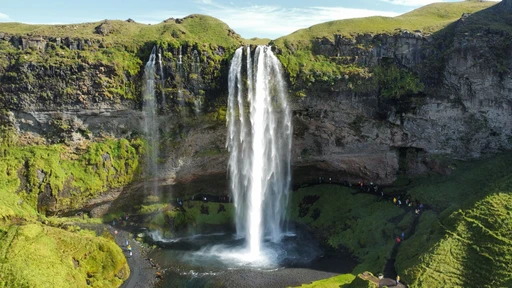 Stunning aerial view of Seljalandsfoss waterfall in Iceland's summer landscape.