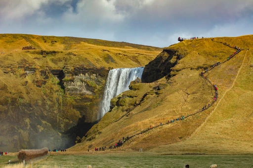 A breathtaking view of Skogafoss waterfall with hikers exploring the vibrant landscape.