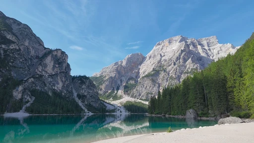 Turquoise water at Lago di Braies with pale Dolomite peaks above the shore.