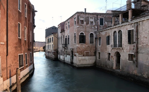 A quiet Venice canal between old buildings on a cool morning.