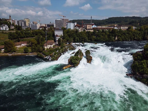 Breathtaking aerial view of Rhine Falls with surrounding townscape in Neuhausen, Switzerland.