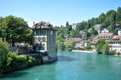 A scenic view of traditional buildings by the turquoise water in Bern, Switzerland.