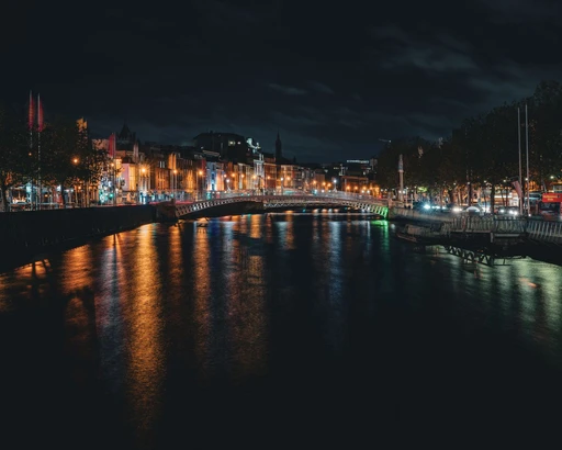 A stunning view of Dublin's Ha'penny Bridge illuminated at night over the River Liffey.
