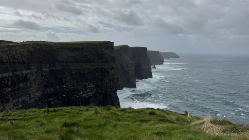 Stunning view of the Cliffs of Moher in Ireland, showing rugged cliffs meeting the Atlantic Ocean.