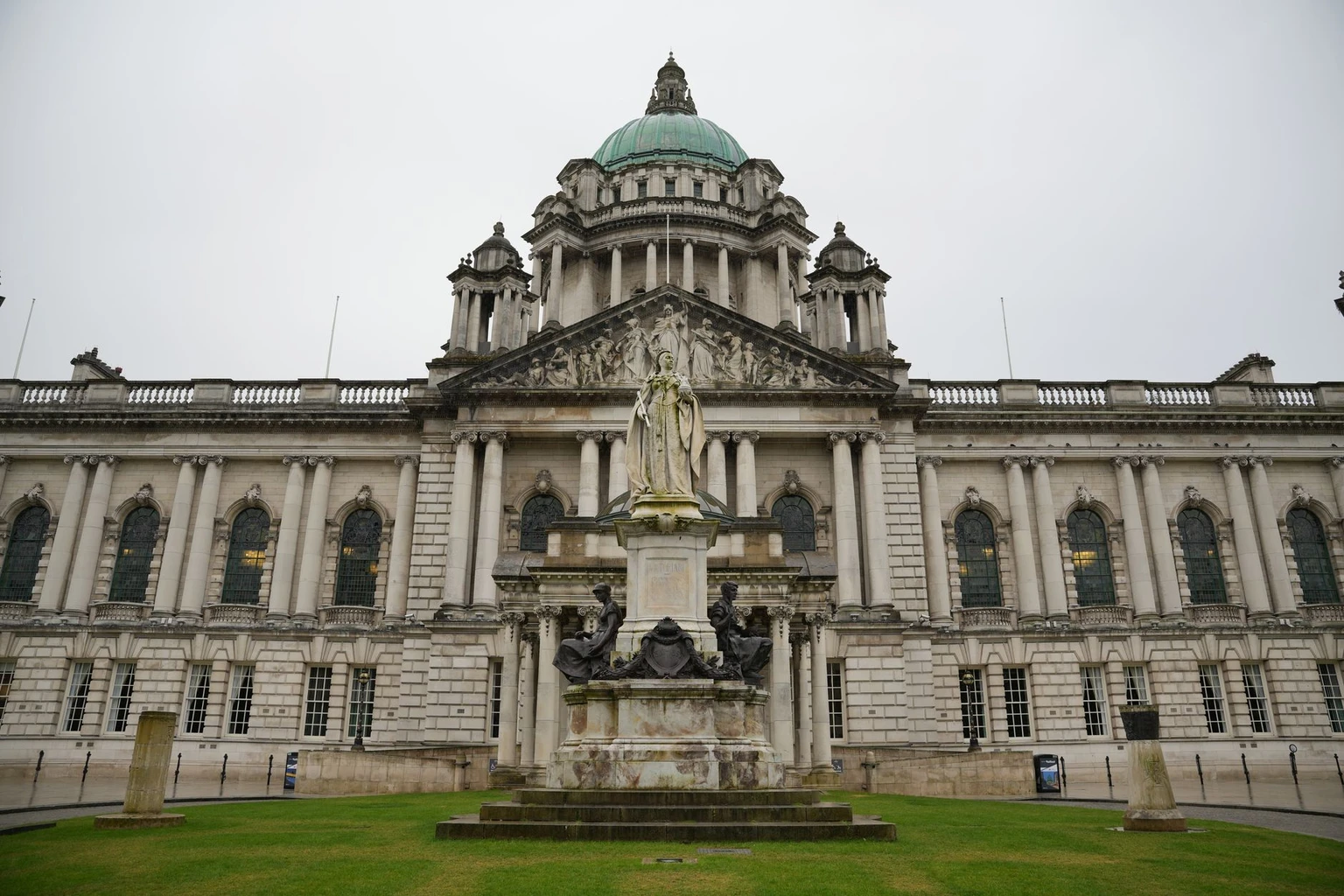 The front of Belfast City Hall, its green dome above the Edwardian facade and the statue in the grounds.