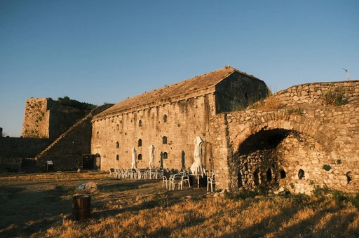 Historic Shkodër Castle in Albania at sunset with empty outdoor seating.