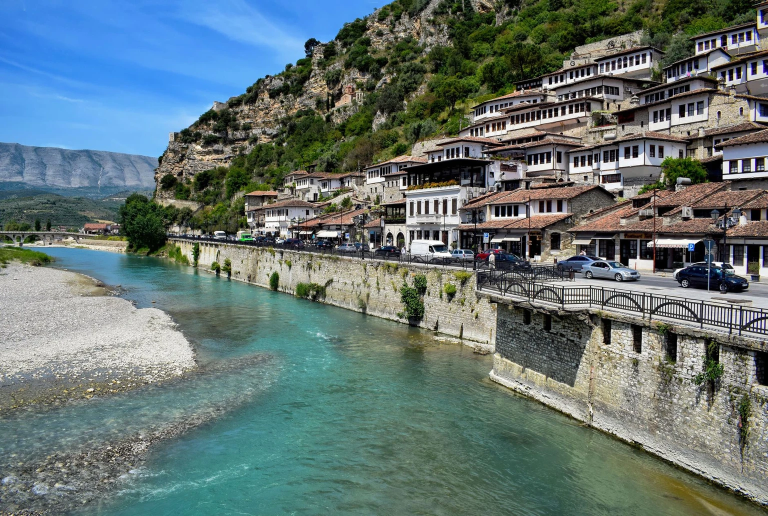 Charming view of Berat, Albania showcasing traditional architecture alongside the Osum River and scenic mountains.