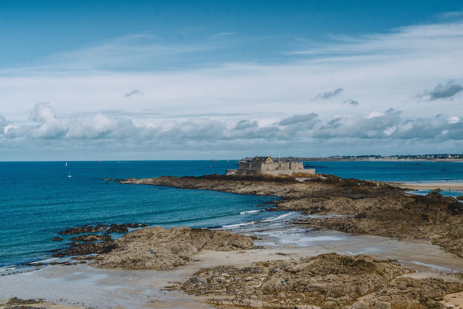 Fort National on its rock off Saint-Malo, seen from the shore at low tide.