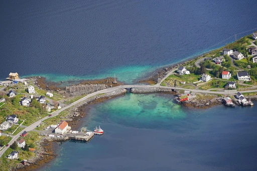 Aerial view of a bridge and small houses at Reine, Lofoten, over turquoise water.