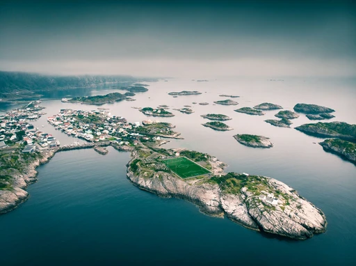 Aerial view of Henningsvær on its islands, with the football pitch on a rock in the foreground, Lofoten.