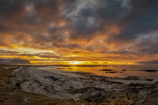 Low golden sun over a flat Arctic beach in Nordland, Norway. Stand-in for the midnight sun; exact beach unconfirmed.