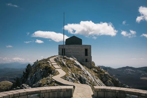 The stone path leading up to the Njegos Mausoleum on Mount Lovcen, with mountains and cloud behind.