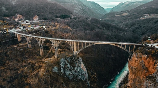 Aerial view of the Djurdjevica Tara Bridge and the turquoise river in the canyon below, in autumn.