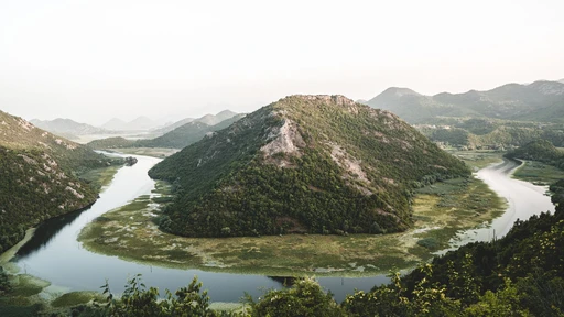 A river bend curling around a green hill near Rijeka Crnojevica, where the river runs toward Lake Skadar.
