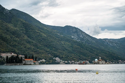 Perast and the Bay of Kotor from the water, with steep mountains rising from the shore.