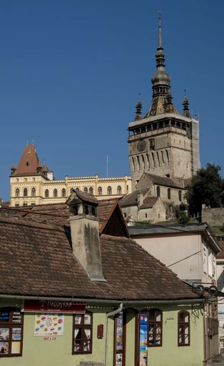 A clock tower and old houses in Sighișoara's medieval citadel.