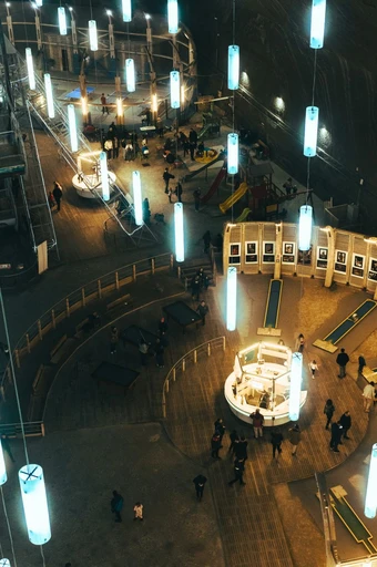 Visitors on the lit wooden leisure area at the bottom of Salina Turda, seen from above.