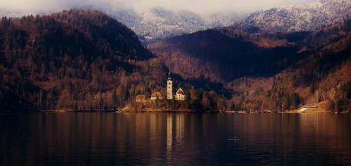 Tranquil scene of an island church surrounded by mountains on Lake Bled, Slovenia.