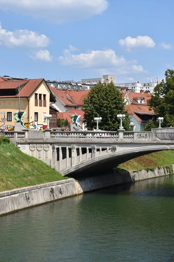 Scenic view of the iconic Dragon Bridge over the Ljubljanica River in Ljubljana, Slovenia on a sunny day.