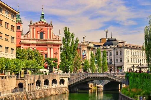 Explore Ljubljana's vibrant cityscape with the Triple Bridge and Franciscan Church on a sunny day.