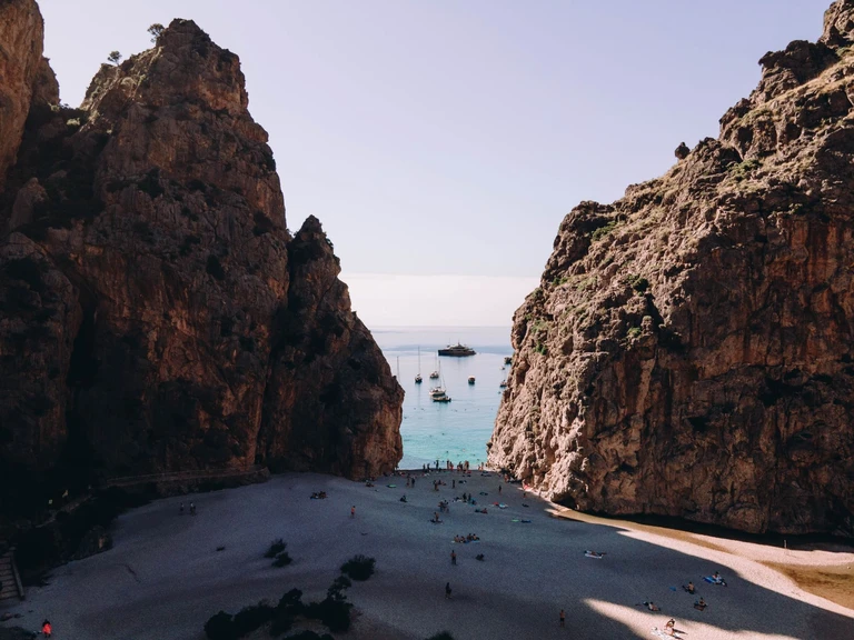 Walk through the cliff to where a gorge ends at the sea