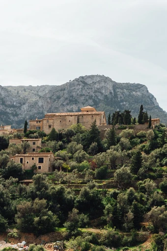 Deià village with traditional stone buildings among greenery in the Tramuntana.