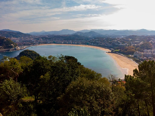 A picturesque aerial view showcasing La Concha Beach and surrounding hills in San Sebastián, Spain.