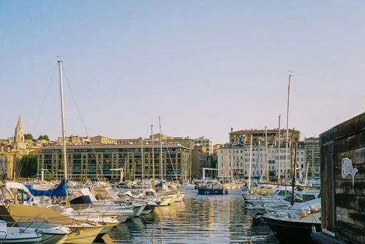 Boats in Marseille's Old Port in warm morning light, with the old waterfront buildings behind.