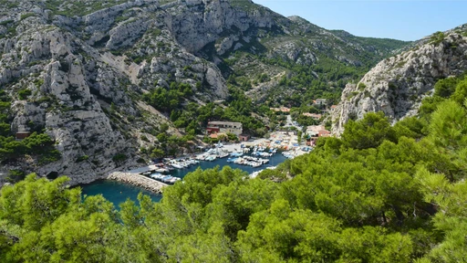 Boats in the narrow harbor of Calanque de Port-Miou, set between limestone cliffs.