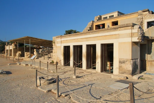 Pale reconstructed walls and doorways of the Knossos palace in low golden light.