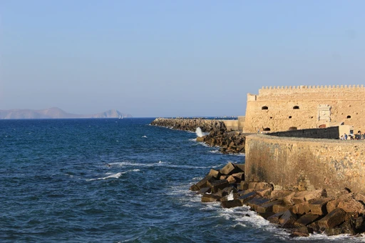 Venetian fortress walls above rocks and the blue sea at Heraklion.
