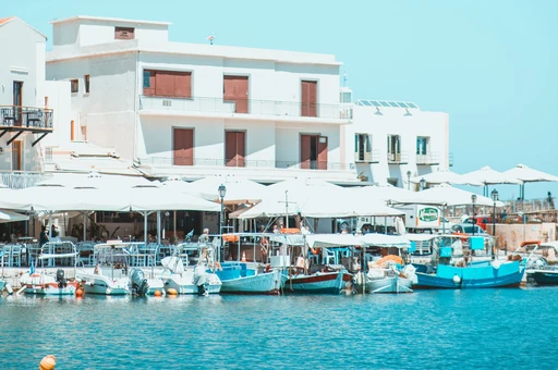 Fishing boats and cafe awnings on the quay in Rethymno's harbor.