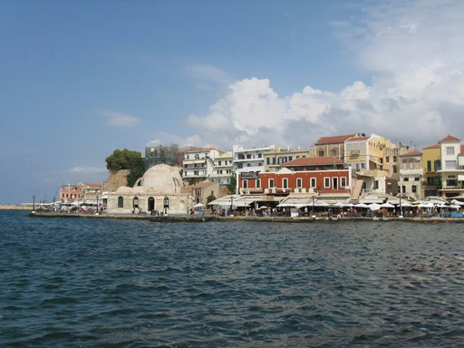 Chania's old harbor waterfront with historic buildings and the domed Hassan Pasha mosque.