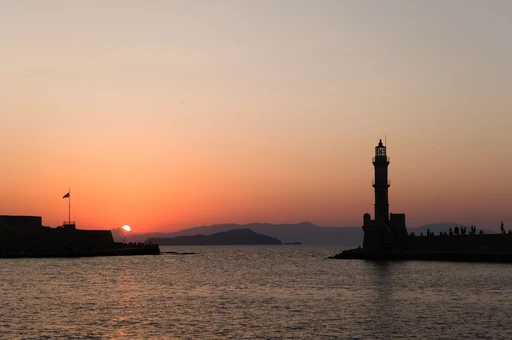 Chania lighthouse at sunset, seen from the harbor.
