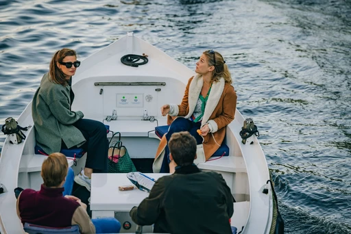 A small open boat with passengers on an Amsterdam canal.