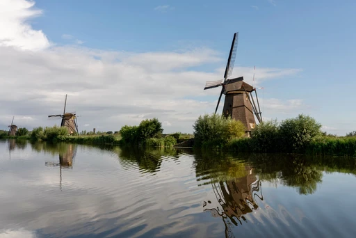 Kinderdijk windmills reflected in still water.